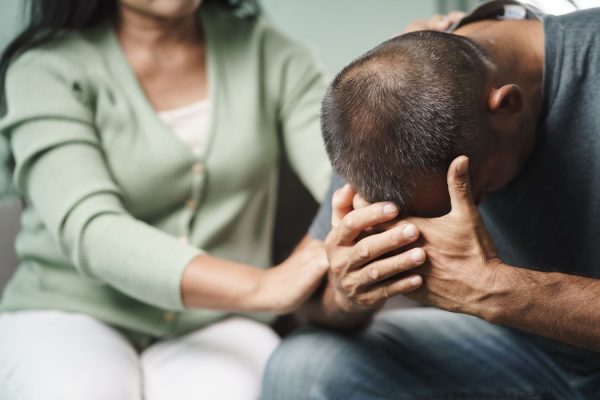 Female Psychologist, friend or family sitting and put hands on the shoulder for cheer up to mental depress man, Psychologist provides mental aid to the patient. PTSD Mental health concept
